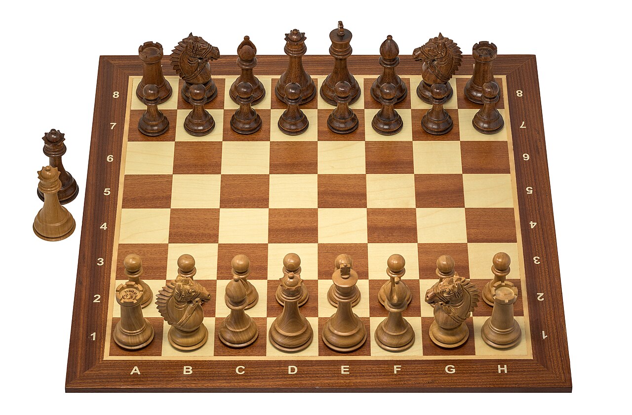 A wooden chess set with the pieces standing ready for a new game