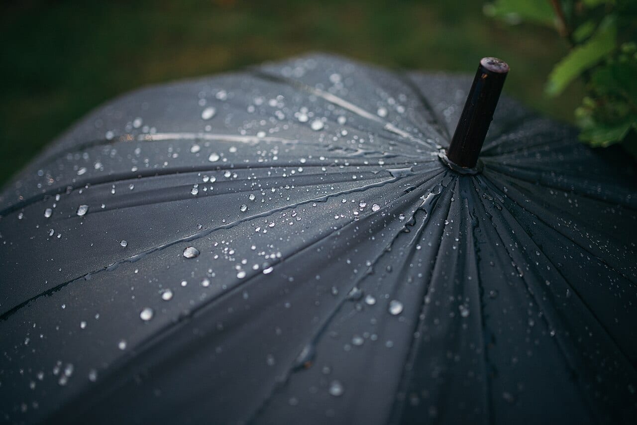 A person holding an umbrella on a rainy street